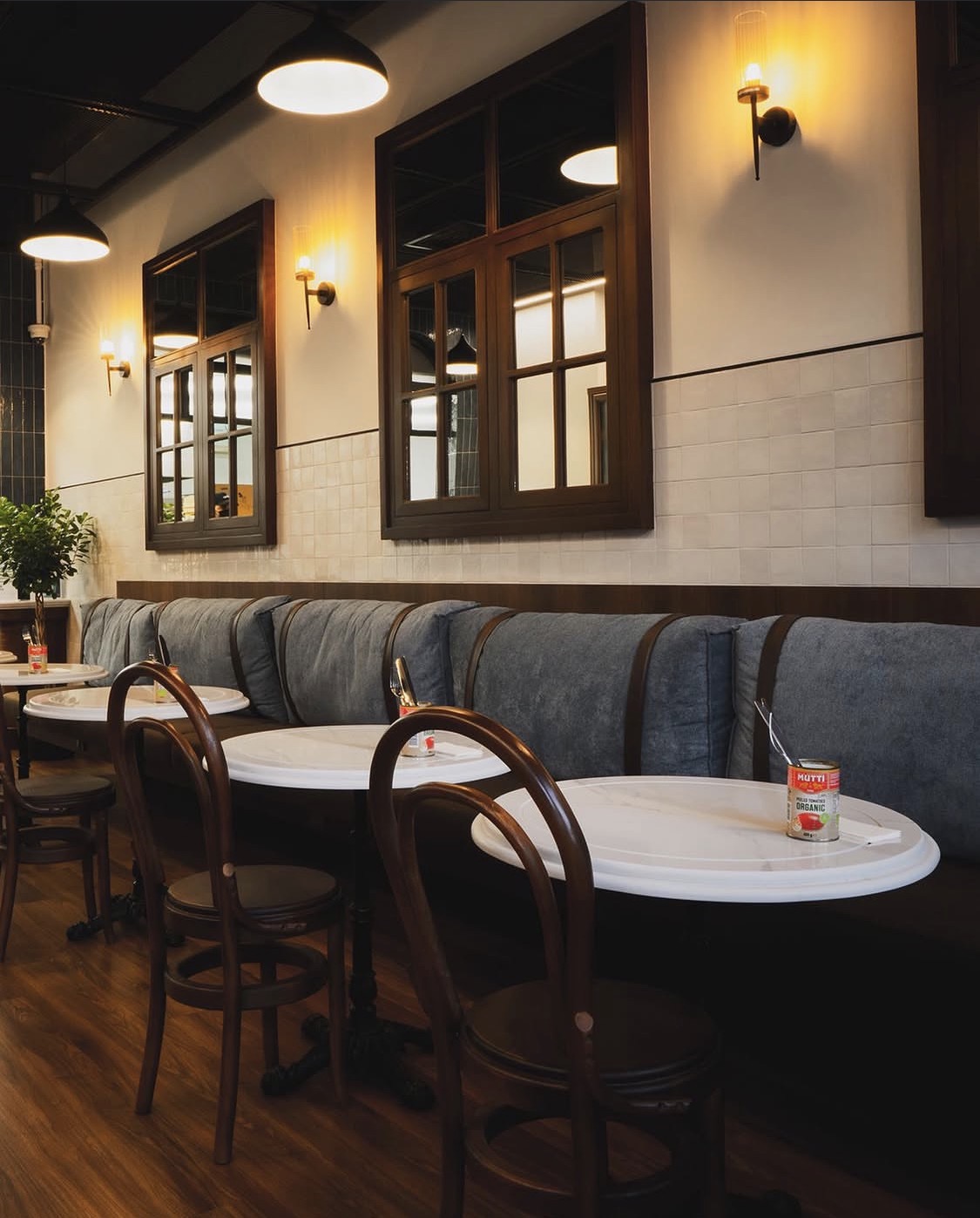 The KRISP dining room with warm lighting, marble tables and bentwood chairs